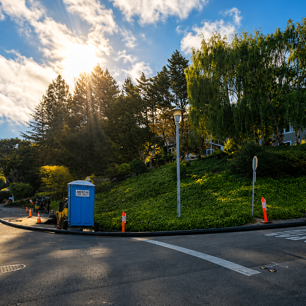 Wide view of a sewer construction project at a residential intersection with trenchless equipment and traffic control.